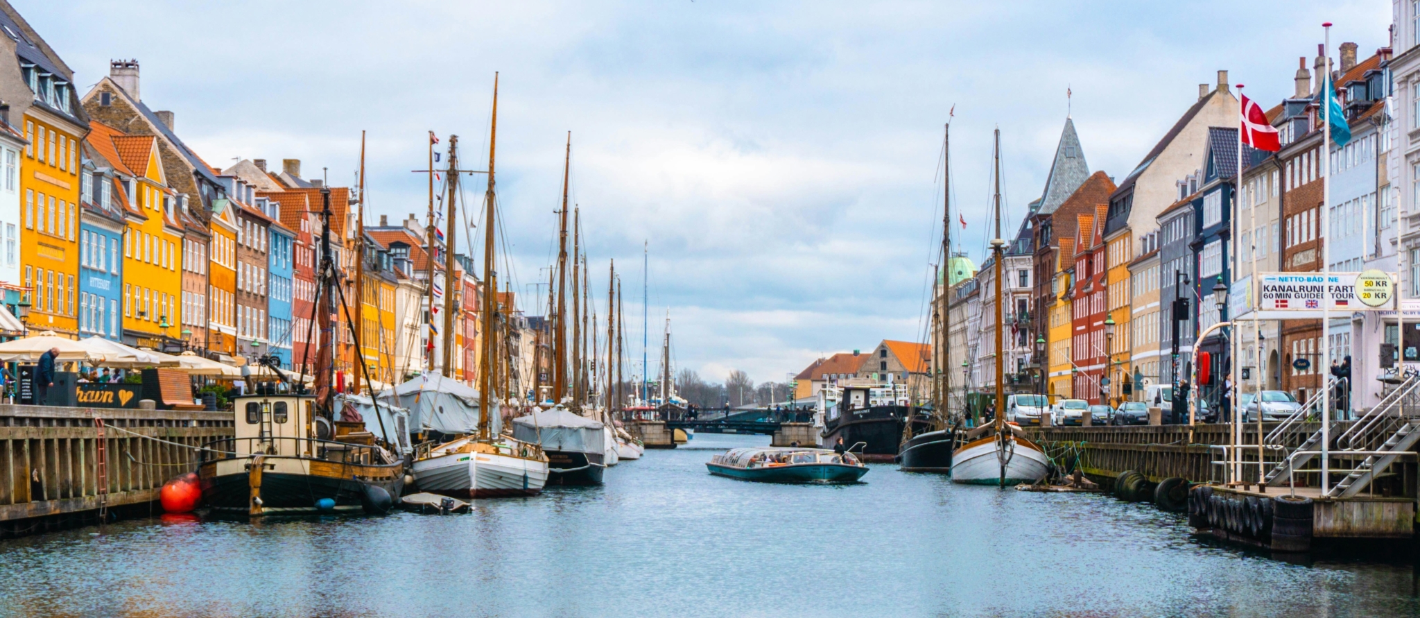 Kleurrijke historische gevels en aangemeerde zeilboten langs de haven van Nyhavn in Kopenhagen, Denemarken.