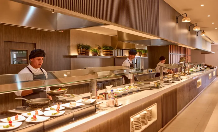 Uitgebreid buffetrestaurant van Zafiro Can Picafort met open keuken en koks die gerechten bereiden.