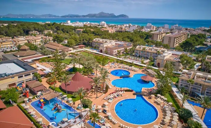 Luchtfoto van Zafiro Can Picafort op Mallorca met meerdere zwembaden, kinderwaterpark en uitzicht richting zee.